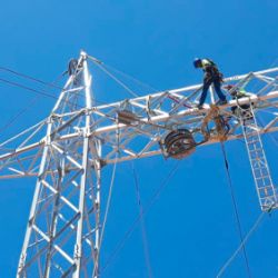 Worker on electrical tower doing the assembly